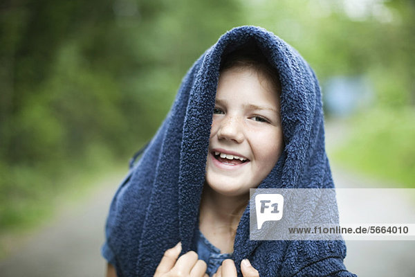Portrait des lächelnden Mädchens mit Handtuch auf dem Kopf