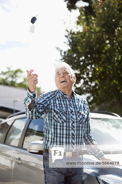 Senior Mann wirft Autoschlüssel in die Luft
