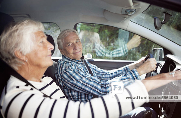Glückliches älteres Paar im Auto sitzend