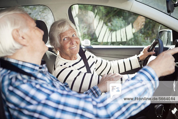 Aktives Seniorenpaar lächelt im Auto