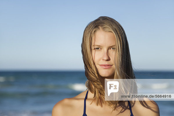 Young woman by ocean  portrait