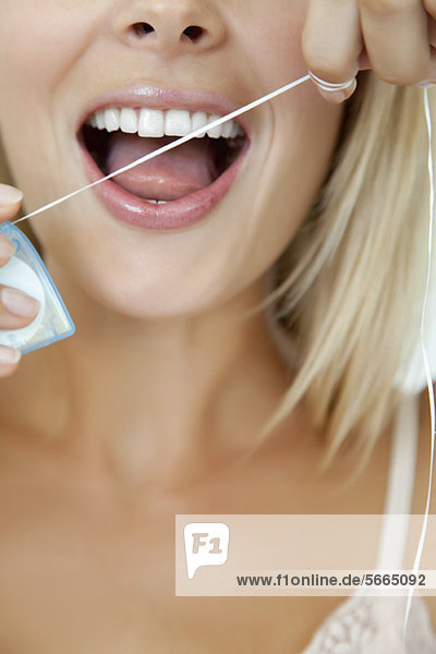 Frau mit Zahnseide  beschnitten