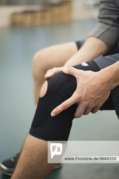 Man wearing knee brace  cropped