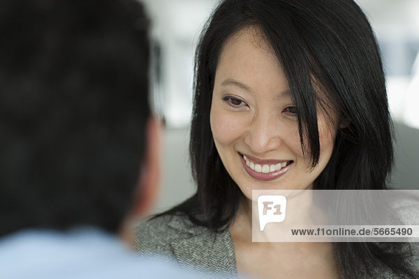 Frau lächelt den Mann im Vordergrund fröhlich an  abgeschnitten
