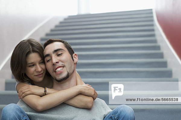 Junges Paar auf der Treppe sitzend  umarmend