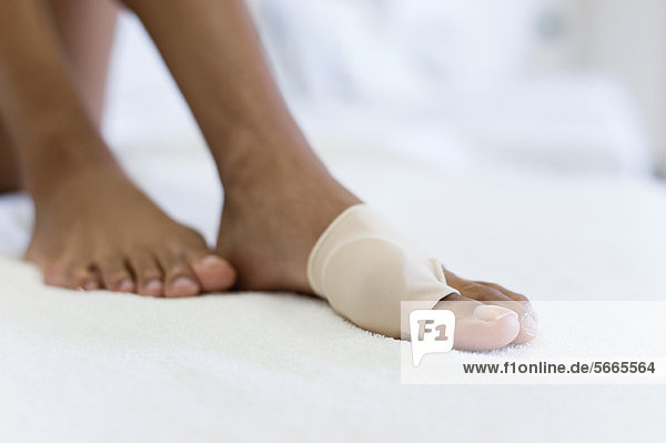Woman's foot wrapped in brace for injured toe  low section