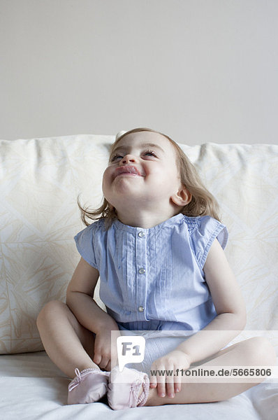 Toddler girl sticking tongue out  full length portrait