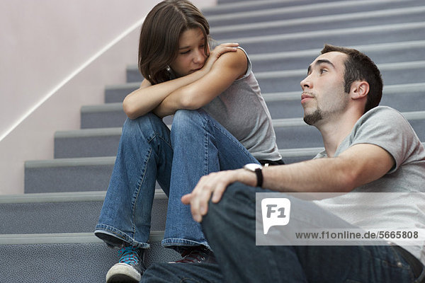 Junges Paar im Gespräch auf der Treppe