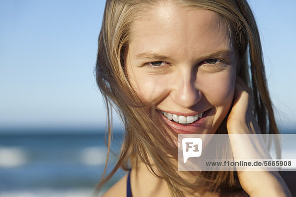 Lächelnde junge Frau mit strubbeligen Haaren  Portrait
