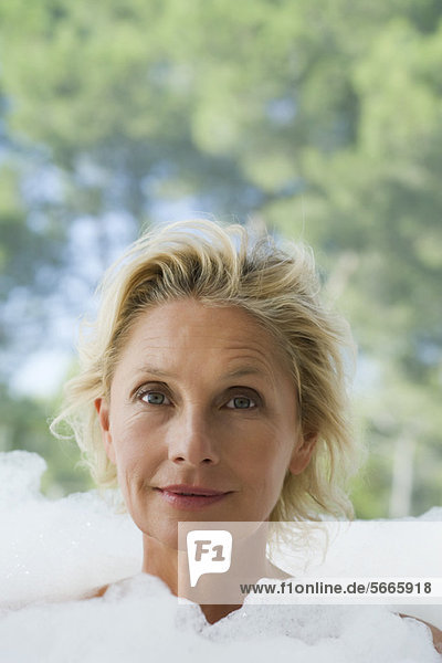 Mature woman in bubble bath  portrait