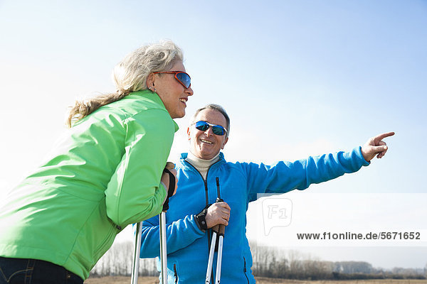 Lächelndes Paar macht Nordic Walking