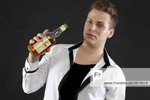 Junger Mann mit Whisky-Flasche