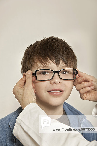 Junge beim Anpassen einer Brille
