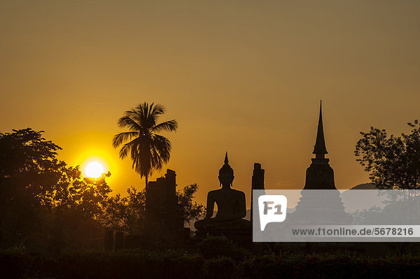 Sitzende Buddha-Statue  Silhouette im Sonnenuntergang  Wat Mahathat  Geschichtspark Sukhothai  Weltkulturerbe der UNESCO  Nordthailand  Thailand  Asien