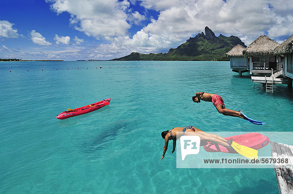 Tourists jumping into the water  St. Regis Bora Bora Resort  Bora Bora  Leeward Islands  Society Islands  French Polynesia  Pacific Ocean
