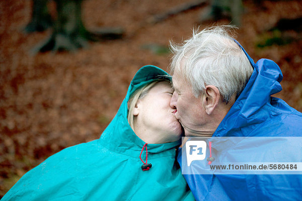 Senior couple wearing waterproofs and kissing