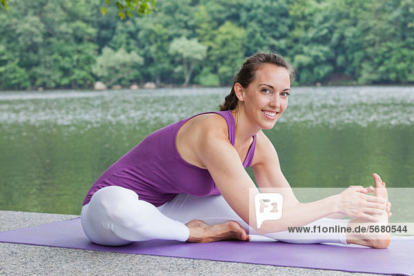 Mittlere erwachsene Frau beim Yoga am Fluss  Portrait
