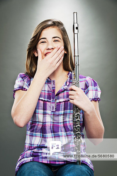 Porträt eines jungen Mädchens  das lacht und Flöte hält.