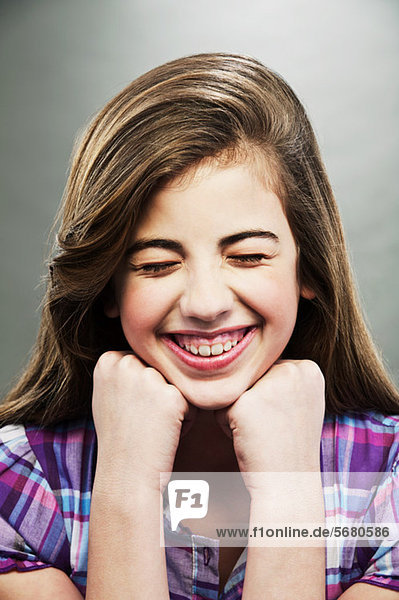 Porträt eines jungen Mädchens  das mit geschlossenen Augen lacht.