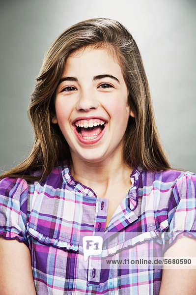 Portrait of young teenage girl laughing  studio shot