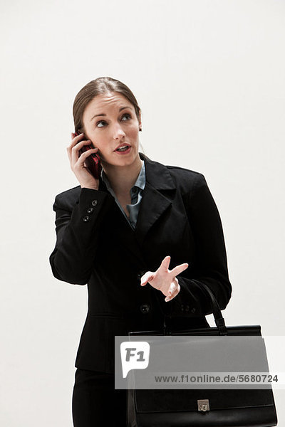Portrait of young businesswoman using cellphone  studio shot
