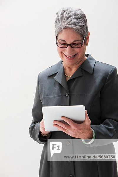 Reife Geschäftsfrau mit digitalem Tablett  Studioaufnahme
