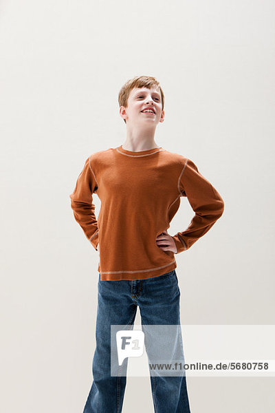 Boy in brown sweater in superhero stance  studio shot