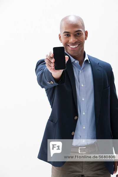 Portrait of African American man holding cellphone  studio shot
