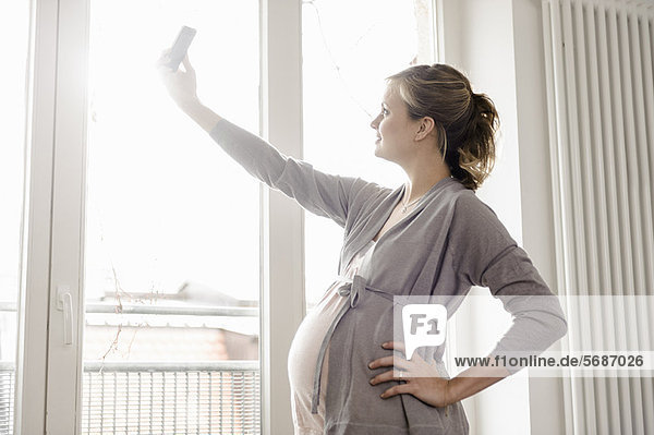 Eine schwangere Frau  die sich selbst fotografiert.
