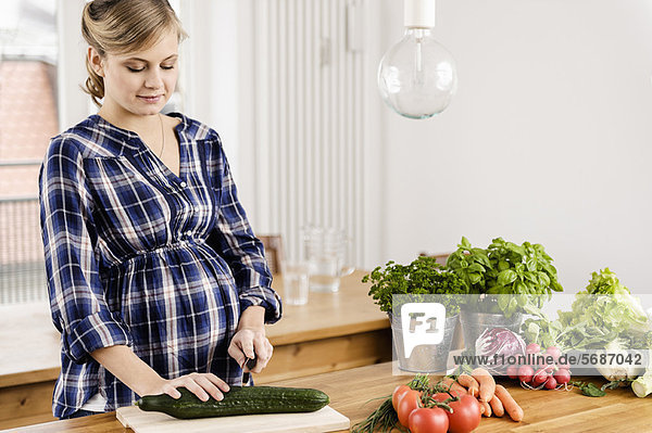 Schwangere Frau beim Schneiden von Gemüse