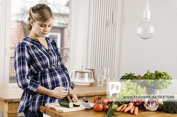 Schwangere Frau beim Schneiden von Gemüse