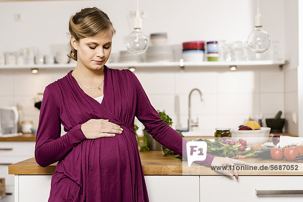 Pregnant woman standing in kitchen