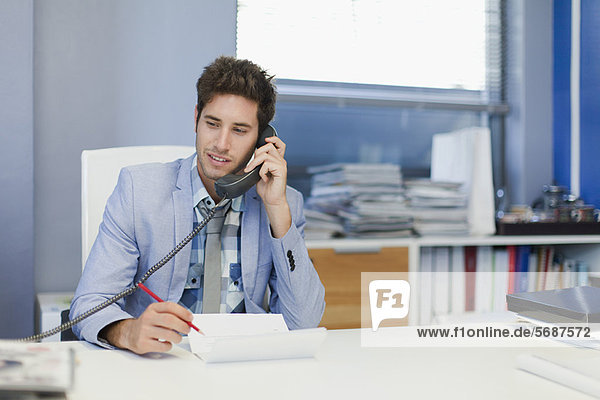 Businessman talking on phone at desk