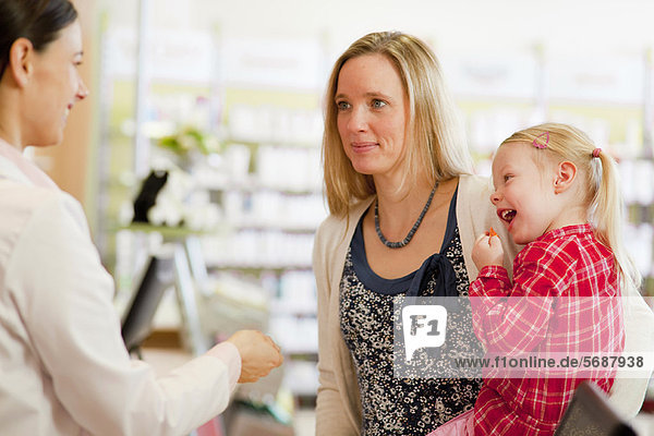 Pharmacist talking to patients in store