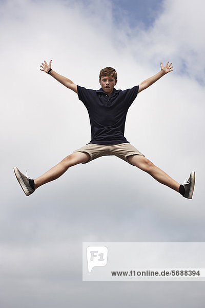 Teenager-Junge posiert in der Luft