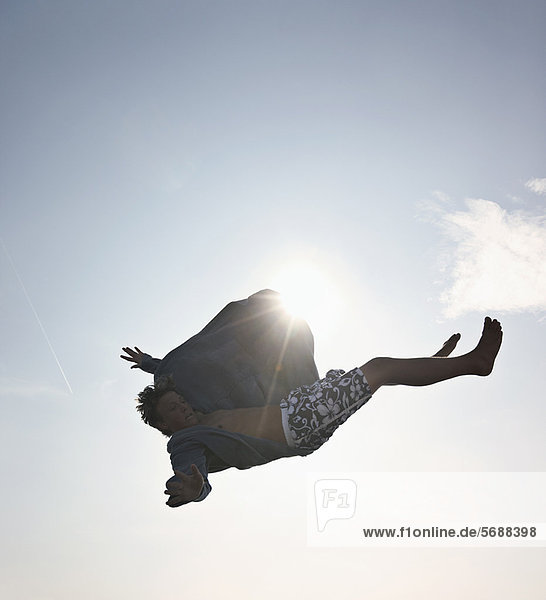 Teenager-Junge posiert in der Luft