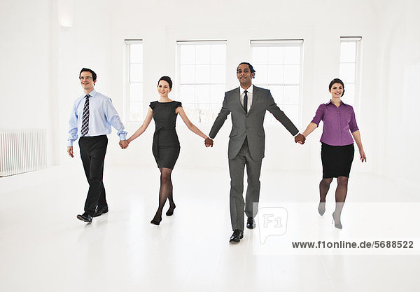 Business people holding hands in office