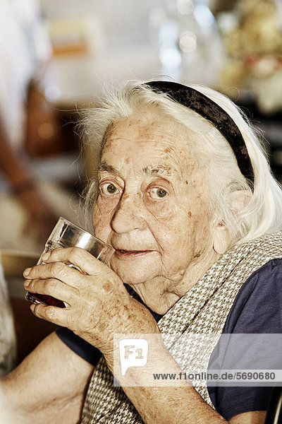 Alte Frau mit Trinkglas