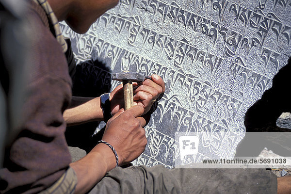 Mann meißelt tibetisch-buddhistische Mantras auf Steinplatte  Zanskar-Tal  Zanskar  Ladakh  Jammu und Kaschmir  indischer Himalaya  Nordindien  Indien  Asien