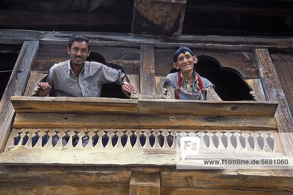 Frau Mann Lifestyle Fenster Tradition Gebäude Ziegelstein Holz hinaussehen bauen Himalaya Himachal Pradesh Asien Indien Schlamm alt
