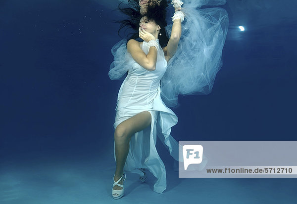 Frau präsentiert Unterwasser-Mode in einem Pool