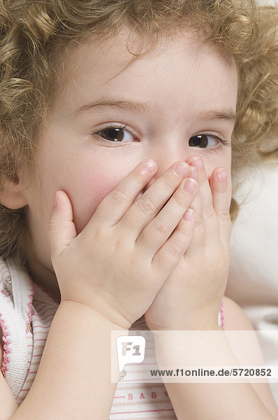 Girl covering mouth with hands