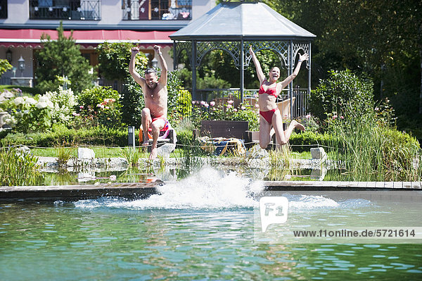 Austria  Salzburg County  Couple jumping into pool