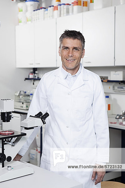 Germany  Bavaria  Munich  Scientist with microscope in laboratory  portrait