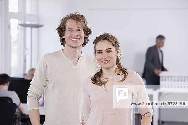 Man and woman standing in office  smiling  portrait