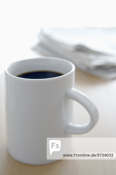 Tasse Kaffee und Zeitung auf dem Bürotisch  Nahaufnahme