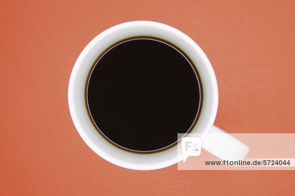 Tasse Kaffee auf orangem Hintergrund  Nahaufnahme