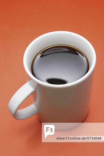 Tasse Kaffee auf orangem Hintergrund  Nahaufnahme
