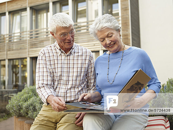 Deutschland  Köln  Seniorenpaar sucht Fotoalbum vor dem Pflegeheim