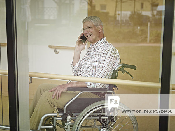 Senior Mann am Telefon im Pflegeheim  lächelnd